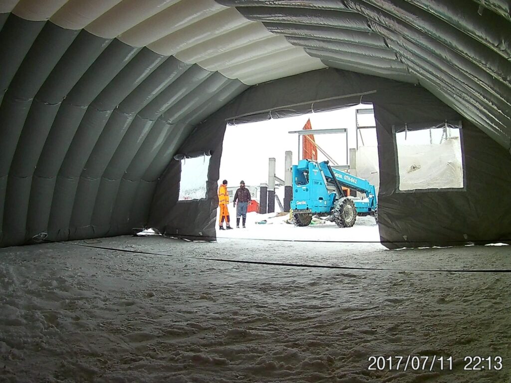 View from inside the Njordair storage tent towards a telehandler at the entrance