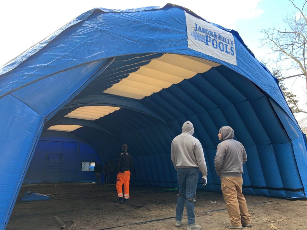 Inside the Jason's Pools branded Njordair tent enclosing a winter pool construction site on Long Island