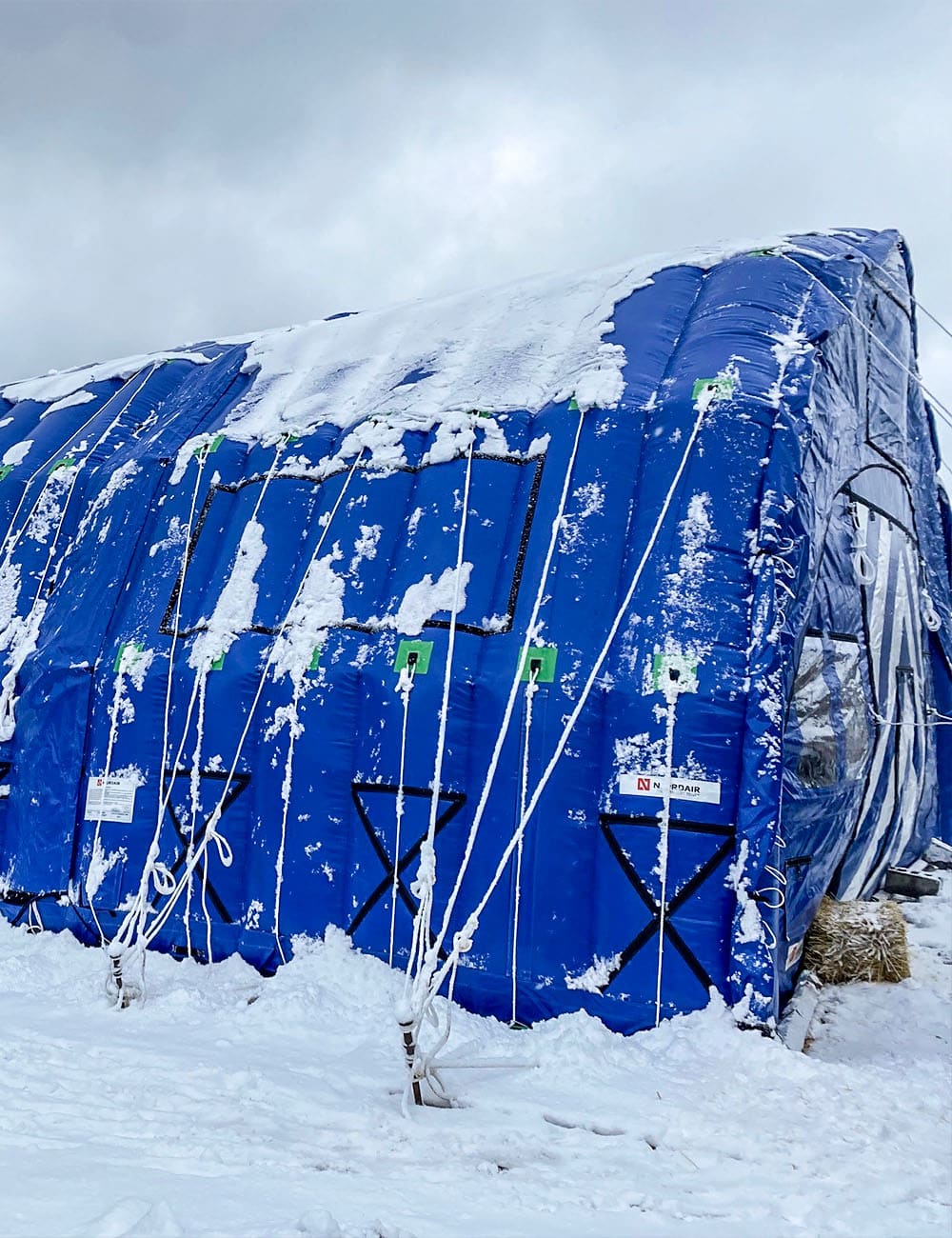 Multiple CA-10 tents linked to form a sheltered work zone, enabling safe roofing in wet, snowy, windy Canadian conditions.